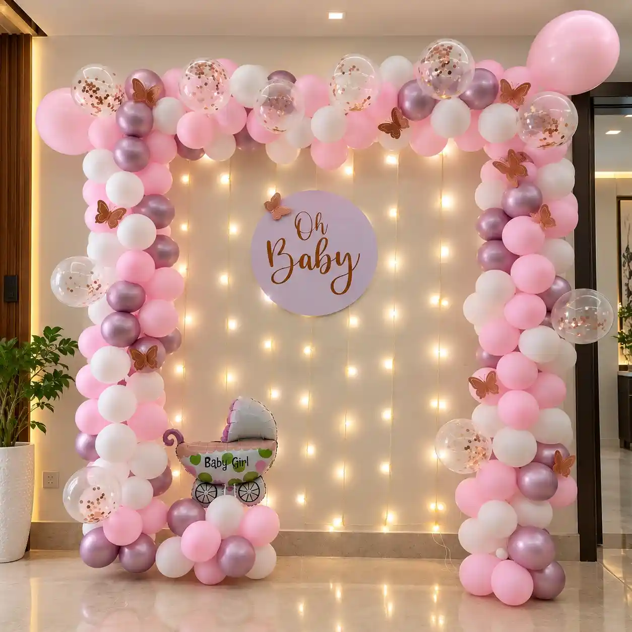 Blush Blossom baby shower decoration with pink and white balloon arch and fairy lights