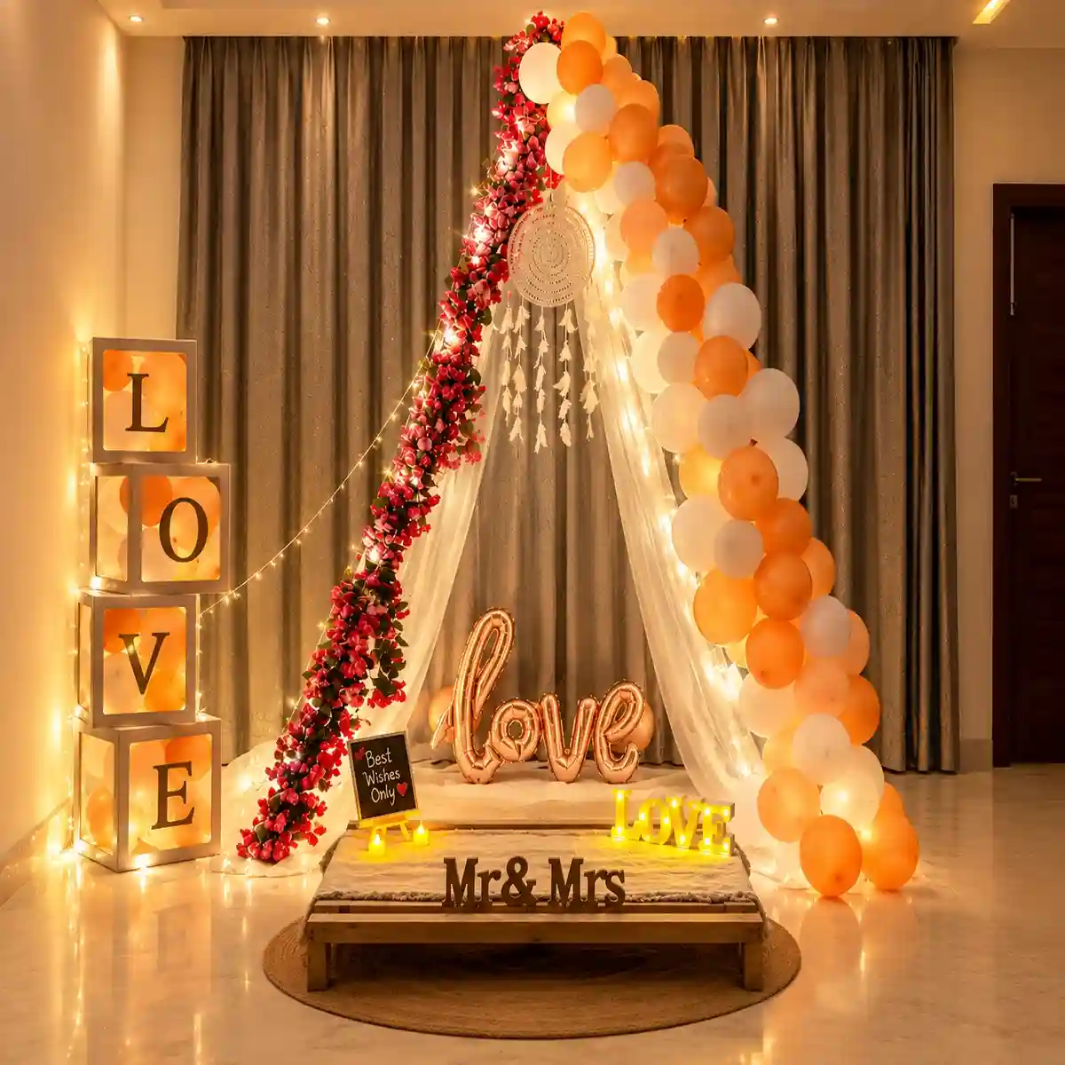 Romantic peach and white love canopy decoration with balloon arch, red floral garland, white net drapes, dreamcatcher, LOVE letters, LOVE foil balloon and Mr & Mrs display.